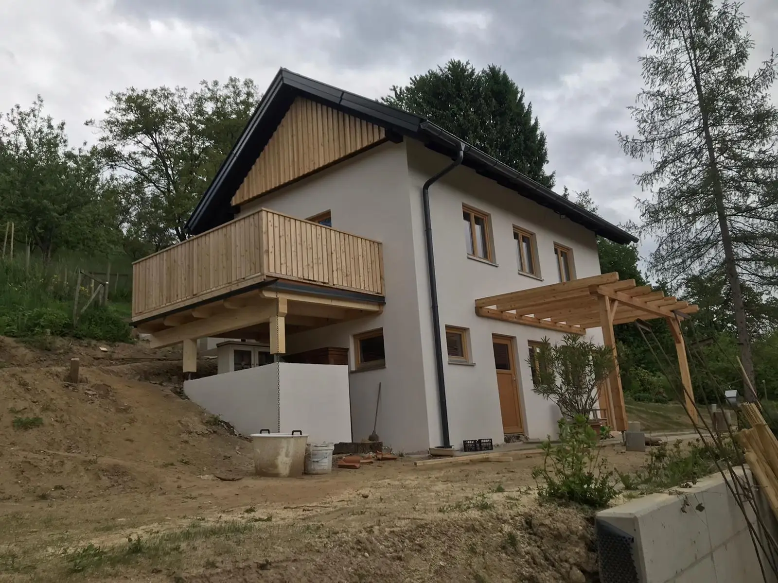 Giebelschalung Deckleiste, Eingangsüberdachung und Terrassenkonstruktion mit Geländer sib. Lärche
