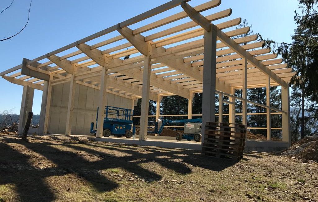 Eine im Bau befindlichen Halle mit Holz-Dachkonstruktion und Betonstützen.