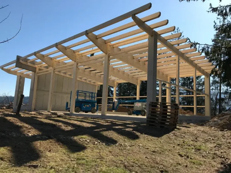 Eine im Bau befindlichen Halle mit Holz-Dachkonstruktion und Betonstützen.